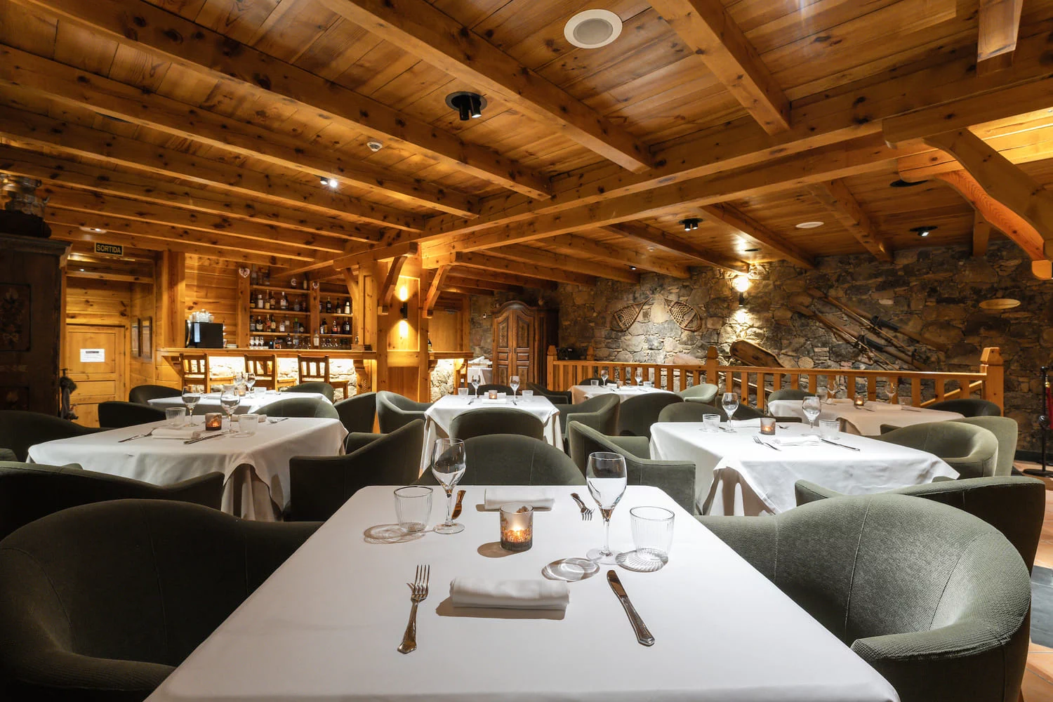 Sala del restaurante con vigas, piedra vista y decoración tradicional, Hotel Xalet Montana, Soldeu