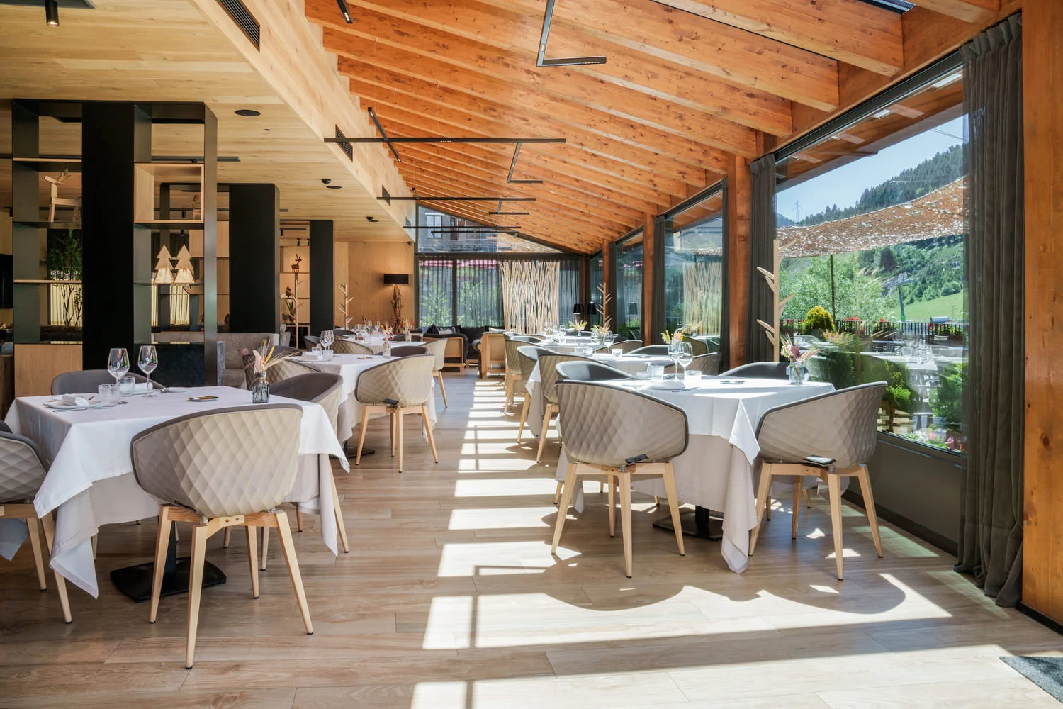 Sala del restaurante Gastronomía Naudi con grandes ventanales y luz natural, Hotel Naudi Boutique